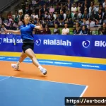 배드민턴 라켓 텐션 조절 팁 - A professional badminton player in mid-action on an indoor court, wearing a full sports outfit inclu...